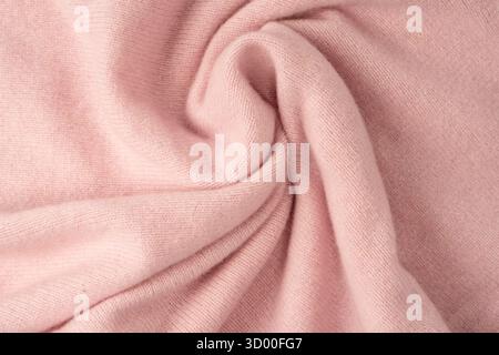 Weicher rosafarbener Kaschmir-Pullover mit Textur im Hintergrund. Draufsicht. Stockfoto