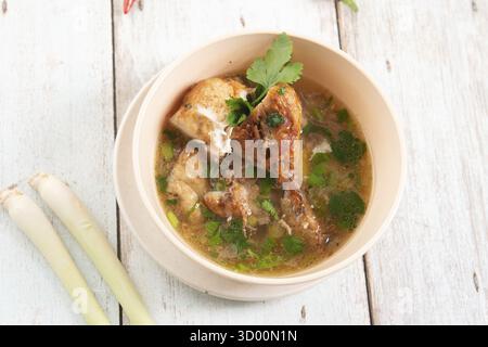 Asiatische Hühnersuppe in Schüssel, hölzerner Hintergrund. Draufsicht flach Stockfoto