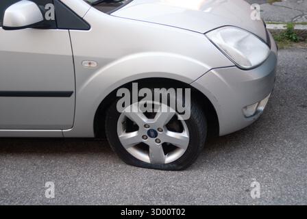 Cremona, Italien - 2. Oktober 2025 Ford Fiesta Silber auf Asphalt geparkt mit einem leeren Vorderrad, Panne am Straßenrand, Reifenreparatur oder Notfall erforderlich Stockfoto