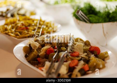 Eine lebendige Salatbar bietet eine Auswahl an frischem Gemüse und Belägen, einschließlich Gemüse, Gurken und anderen bunten Zutaten, perfekt für gesunde Gesundheit Stockfoto