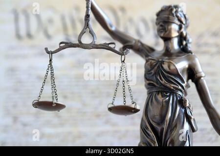 Die Statue der Gerechtigkeit Themis, die Göttin der Gerechtigkeit mit den Augen gegen die US-Verfassung Seite. Urteil und Strafe in den Vereinigten Staaten Stockfoto