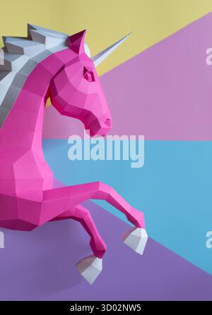 Geometrischer Rosafarbener Einhorn-Skulptur Doppelter Hintergrund. Auffällige und moderne geometrische Einhornskulptur in rosa weiß steht vor gespaltenem rosa violetten Hintergrund Stockfoto