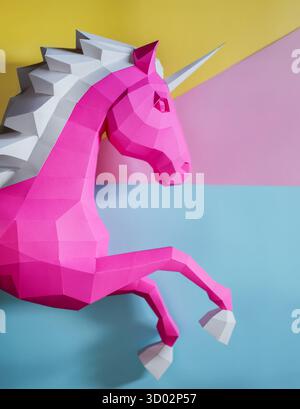 Geometrischer Rosafarbener Einhorn-Skulptur Doppelter Hintergrund. Auffällige und moderne geometrische Einhornskulptur in rosa weiß steht vor gespaltenem rosa violetten Hintergrund Stockfoto