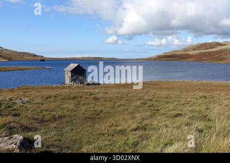 Das Old Remote Stone Boathouse am Devoke Water im Lake District National Park, Cumbria, England, Großbritannien. Stockfoto