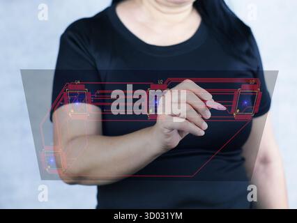 Dieses Bild zeigt eine Frau, die einen Stift auf eine virtuelle elektronische Leiterplatte zeigt, die in der Luft schwebt. Stockfoto