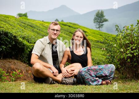Wunderschönes junges kaukasisches Paar Touristen auf Teefeldern in den indischen Munnar Bergen. Üppige grüne Landwirtschaft in Südindien. Stockfoto