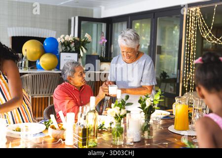 Ein älteres Ehepaar mit Familie lacht bei einem Treffen im Freien. Feiern, Zweisamkeit, draußen, Party, Mehrgenerationen, Happiness || Model veröffentlicht Stockfoto