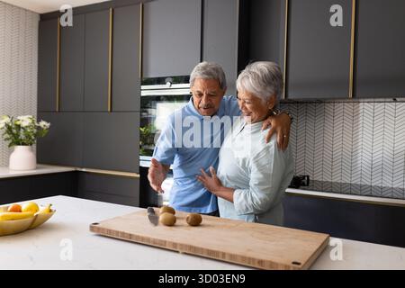 Älteres Ehepaar in der modernen Küche, das Essen zusammen zubereiten, freudige Momente teilen. Kochen, Lebensstil, Glück, Zweisamkeit, kulinarische, Inland || Modell freigegeben Stockfoto