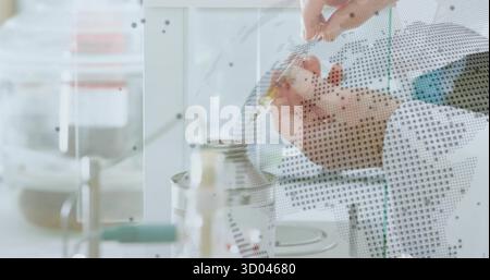 Latex-Forscher im Laborkitt, der Flüssigkeit in einen Behälter im Labor pipettiert, mit gepunkteter Trennwand Stockfoto