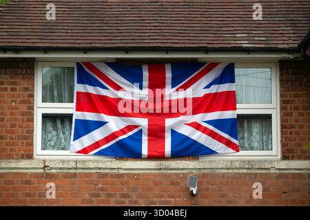 Eine Union Jack Flagge hängt von einem Haus in Weoley Castle, einem Vorort im Südwesten von Birmingham, wo Union Jack Flags und St George's Flaggen haben Stockfoto