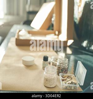 Umweltfreundliche Verpackung mit natürlichen Materialien und Gläsern auf dem Tisch bei Sonnenlicht. Stockfoto