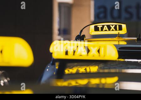 Schwarze und gelbe Taxischilder auf den Dächern eines Autos Stockfoto