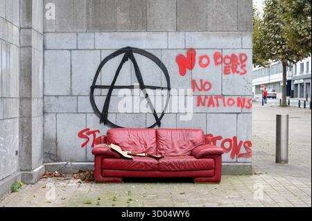 Rotes verlassenes Sofa und Protestschild des linken Flügels in Brüssel-Hauptstadt, Belgien 12. OKT 2025 Stockfoto