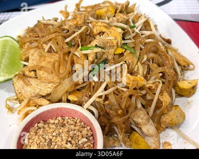 Traditionelle Thai Pad Thai Nudeln mit Huhn, Ei, Sojasprossen, Limette und gemahlenen Erdnüssen. Asiatisches Street Food-Konzept. Stockfoto