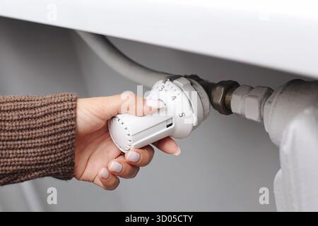 Handeinstellung des Kühlerthermostatventils Heizungssteuerung. Energiesparkonzept und Temperaturregelung. Stockfoto