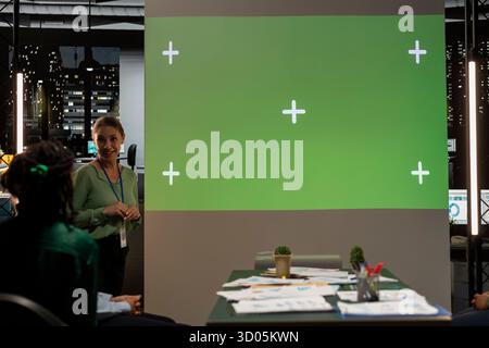 Das multiethnische Projektteam arbeitet spät in einem dunklen Büro mit Kopierraum und arbeitet bei einem nächtlichen Meeting in einem multinationalen Unternehmen an der Budgetierung, Berichterstellung und der Festlegung von Geschäftszielen. Stockfoto