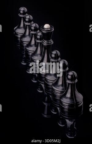 Schwarze Schachfiguren stehen in Reihe. Schachfiguren auf Schachbrett mit selektivem Fokus. Geschäfts- und Motivationskonzept. Kopierbereich Stockfoto