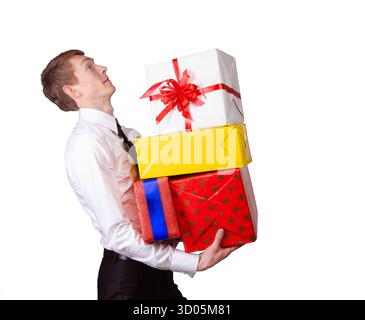 Ein Mann in Hemd und Krawatte hält mehrere farbenfrohe Geschenkboxen, die Feierlichkeiten, Feiertage oder Großzügigkeit repräsentieren. Stockfoto