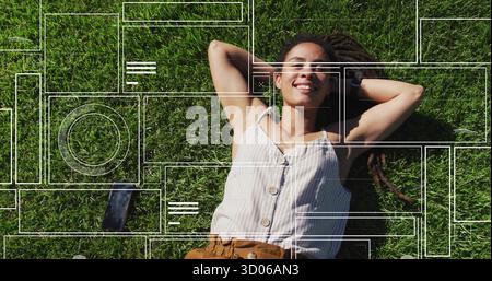 Liegende Frau mit gestreiftem Oberteil, brauner Hose auf Gras, mit Armbanduhr und Smartphone-Overlay Stockfoto