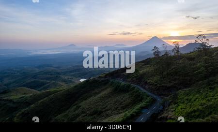 Atemberaubendes Luftbild, das den Sonnenaufgang über einer riesigen, trüben Berglandschaft in Flores einfängt. Stockfoto