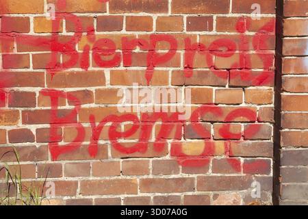 Rote Bierpreisbremse auf rötliche Ziegelwand gesprüht, Deutschland Stockfoto