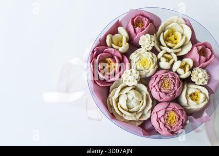 Ein Blumenstrauß aus rosa und weißen Blumen aus Seife. Die Blüten werden in einer runden rosafarbenen Box mit einem rosafarbenen Band gesammelt. Platz zum Schreiben Stockfoto
