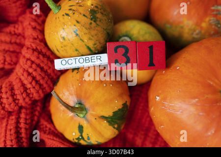 Holzwürfelkalender zeigt am 31. Oktober Halloween die Vorbereitung von Kürbissen zum Schnitzen. Feiertags- und Partykonzept Stockfoto