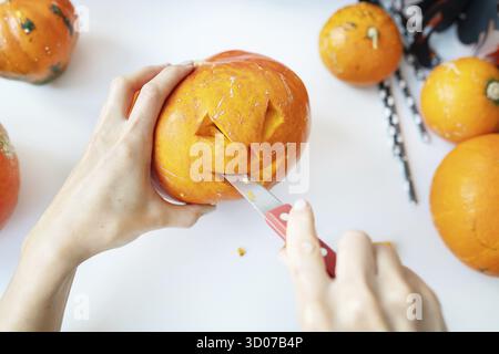 Halloween am 31. Oktober. Der Schritt-für-Schritt-Prozess des Schnitzens eines Kürbisses. Blick von oben Stockfoto