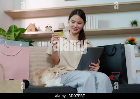 Content Shopper nutzt das Tablet mit Cat an ihrer Seite Stockfoto