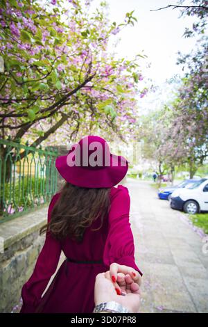Die Frau im roten Kleid die Hand des Menschen Stockfoto