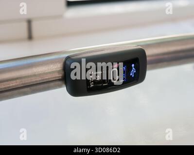 Eine 5-V-USB-Buchse Typ A und Typ C zum Aufladen von Smartphones, die an einem Handlauf in einem Bus oder Zug befestigt sind, für den Komfort der Passagiere Stockfoto