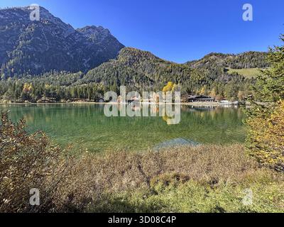 Ruhiger See mit Bergen im Hintergrund und bunten Herbstblättern, Toblacher See, Toblacher See, Südtirol, Italien Stockfoto