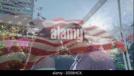 Paare in formeller Kleidung küssen sich unter Pergola im Garten, mit Wimpelbanner, Konfetti, Fahnenüberzug Stockfoto