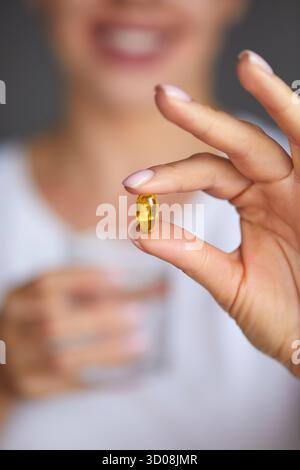 Nahaufnahme Der Schönen Frauenhand Mit Bunten Vitaminen Und Pillen Auf Palm. Mädchen Mit Tabletten, Kapseln Und Einem Glas Süßwasser. Vitamin Und Diät Stockfoto