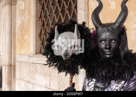 Schwarz-weiße Teufelsmasken mit Hörnern und Bärten, ausgestellt am Karneval in Venedig, Italien - traditionelle Kostümzubehör Stockfoto