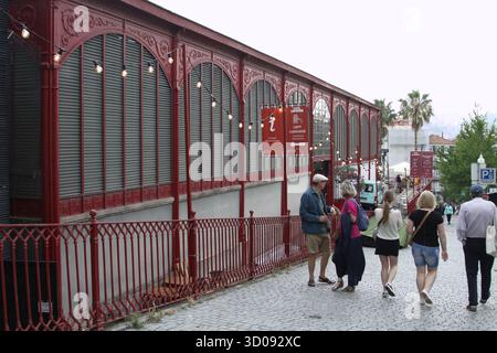 Porto, Portugal - 10. Juni 2025: Mercado Ferreira Borges, zeigt seine lebhafte rote Architektur mit belebten Fußgängern in lebendiger Atmosphäre. Stockfoto
