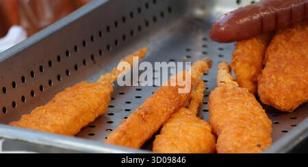 Verschiedene frittierte koreanische Street Food Snacks, die in einem Metalltablett abfließen Stockfoto