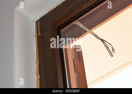 Alte Holzfenster und Balkontüren in einem alten Haus ersetzen. Reparatur in der Wohnung. Installation neuer Fenster und Balkontüren. Hausrenovierung. Stockfoto