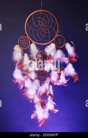 Schöner Traumfänger und Rauch in Farbe hell auf dunklem Hintergrund Stockfoto