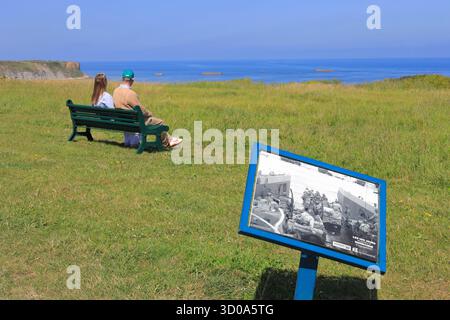 Frankreich, Calvados (14), Arromanches-les-Bains, Ansicht der Überreste des alten Fertighafens der Alliierten (Mulberry-Hafen) während der Landungen in der Normandie mit der Reproduktion eines historischen Fotos Stockfoto