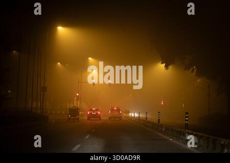 Gurgaon, Haryana, Indien. Oktober 2025. Ein einsames Verkehrszeichen leuchtet schwach durch dichten Diwali-Smog in NEU-DELHI, während die Stadt trotz der Beschränkungen für Feuerwerkskörper mit der Verschlechterung der Luftqualität zu kämpfen hat. Der toxische Dunst, der heute jährlich nach dem Festival stattfindet, verwischt die Sicht und schwächt die festlichen Lichter, die einst die Feiertage prägten. (Kreditbild: © Shubhadeep Mukherjee/ZUMA Press Wire) NUR REDAKTIONELLE VERWENDUNG! Nicht für kommerzielle ZWECKE! Stockfoto