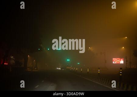 Gurgaon, Haryana, Indien. Oktober 2025. Neu-Delhi, Indien: Ein leeres Verkehrszeichen, das in dichten Diwali-Smog gehüllt ist, leuchtet leicht durch den Dunst, auf dem Premierminister Narendra Modi die Diwali-Grüße zeigt. Bei fast ausbleibendem Verkehr und geringer Sicht fängt die Szene den starken Kontrast zwischen festlichen Feierlichkeiten und der sich verschlechternden Luftqualität der Stadt während der Festivalsaison ein. (Kreditbild: © Shubhadeep Mukherjee/ZUMA Press Wire) NUR REDAKTIONELLE VERWENDUNG! Nicht für kommerzielle ZWECKE! Stockfoto