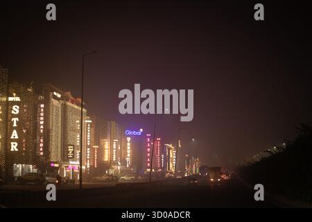 Gurgaon, Haryana, Indien. Oktober 2025. Die Gebäude und Geschäfte in GURUGRAM leuchten in der Diwali-Nacht hell mit festlichen Lichtern, selbst wenn eine dicke Schicht von Smog aus brennenden Feuerwerkskörpern die Stadt umhüllt. Während die Feierlichkeiten andauern, kämpfen die Bewohner mit schlechter Luftqualität und Atembeschwerden, was die zunehmende Umweltbelastung durch die Festspiele in der Region der nationalen Hauptstadt unterstreicht. (Kreditbild: © Shubhadeep Mukherjee/ZUMA Press Wire) NUR REDAKTIONELLE VERWENDUNG! Nicht für kommerzielle ZWECKE! Stockfoto