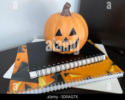 Halloween-Komposition mit Kürbis und Notizbüchern, orange, schwarz und weiß Stockfoto