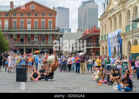 New Orleans, LA, USA – 19. April 2025: Seitenansicht des Straßenkünstlers akrobat, der in der Luft schwingt, während er vor einer Menge Zuschauer auf dem historischen Jackson Square im French Quarter einen Flip dreht Stockfoto