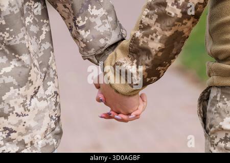 Zwei Soldaten der US-Armee in digitalen Tarnuniformen halten die Hände im Freien und vermitteln Unterstützung und Verbindung. Ein leistungsstarkes Bild, das ca. Stockfoto