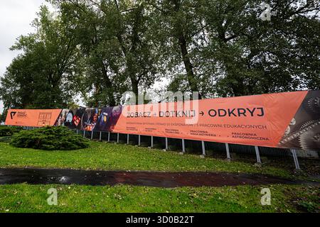 Tarnow, Polen - 10. Oktober 2025: Großes orangePasaż Odkryć-Banner zeigt interaktive Ausstellungen entlang eines Zauns in Tarnow Polen. Stockfoto