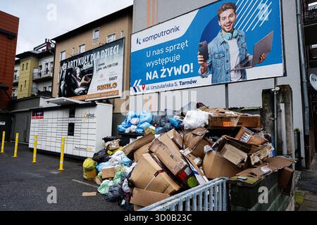 Tarnow, Polen - 10. Oktober 2025: Straßenszene mit überlaufendem Müll und Pappe in der Nähe von Anzeigen in Tarnow, Polen. Stockfoto