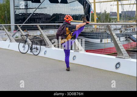 Ein Mann, der sein Bein draußen streckt, Glasgow, Schottland, Großbritannien Stockfoto