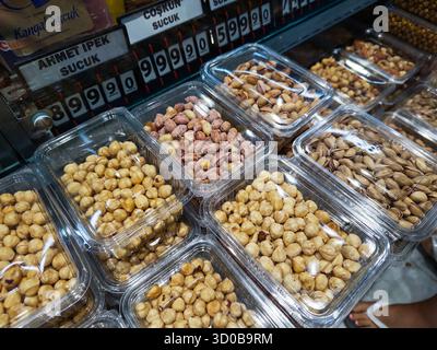 4. Juli 2025, Istanbul, Türkei. Farbenfrohe Auswahl verschiedener Nusssorten in transparenten Behältern auf einem lokalen Markt in der Türkei. Stockfoto